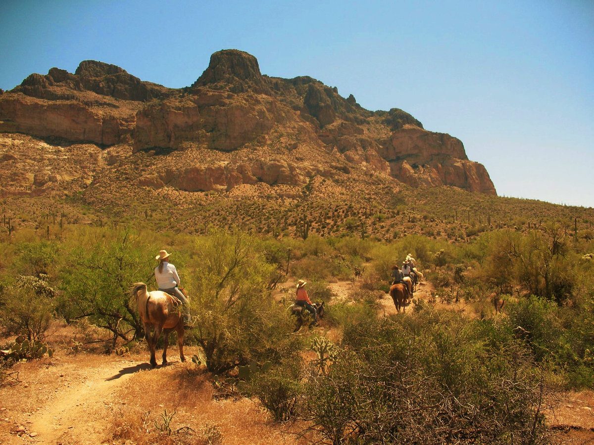 Riders below the cliffs